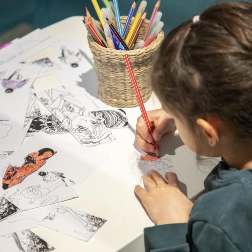 jeune visiteuse en train de colorier une image dans l'exposition Miyazaki